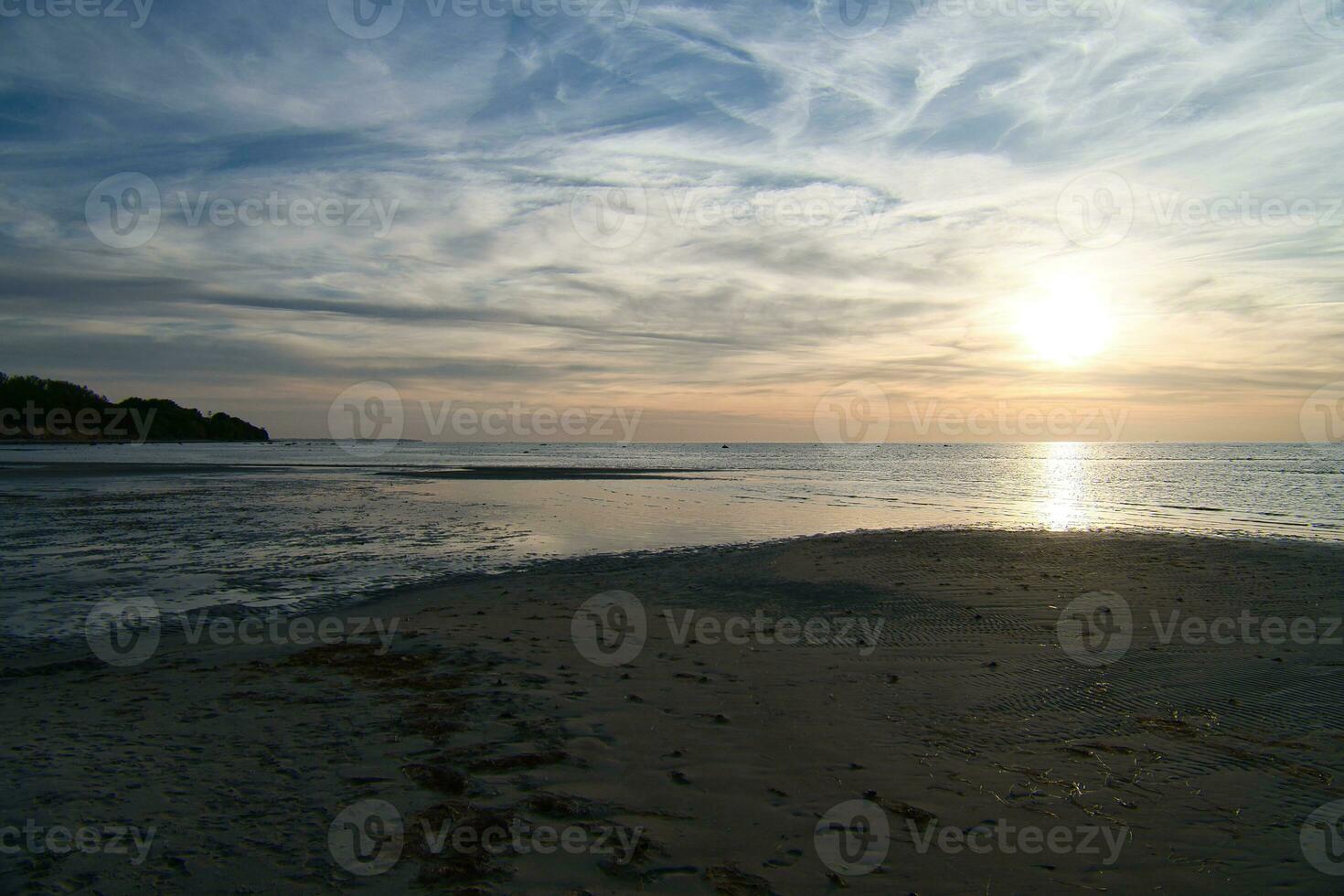 Sonnenuntergang, Aussicht Über das sandig Strand zu das beleuchtet Meer. Licht Wellen. baltisch Meer foto