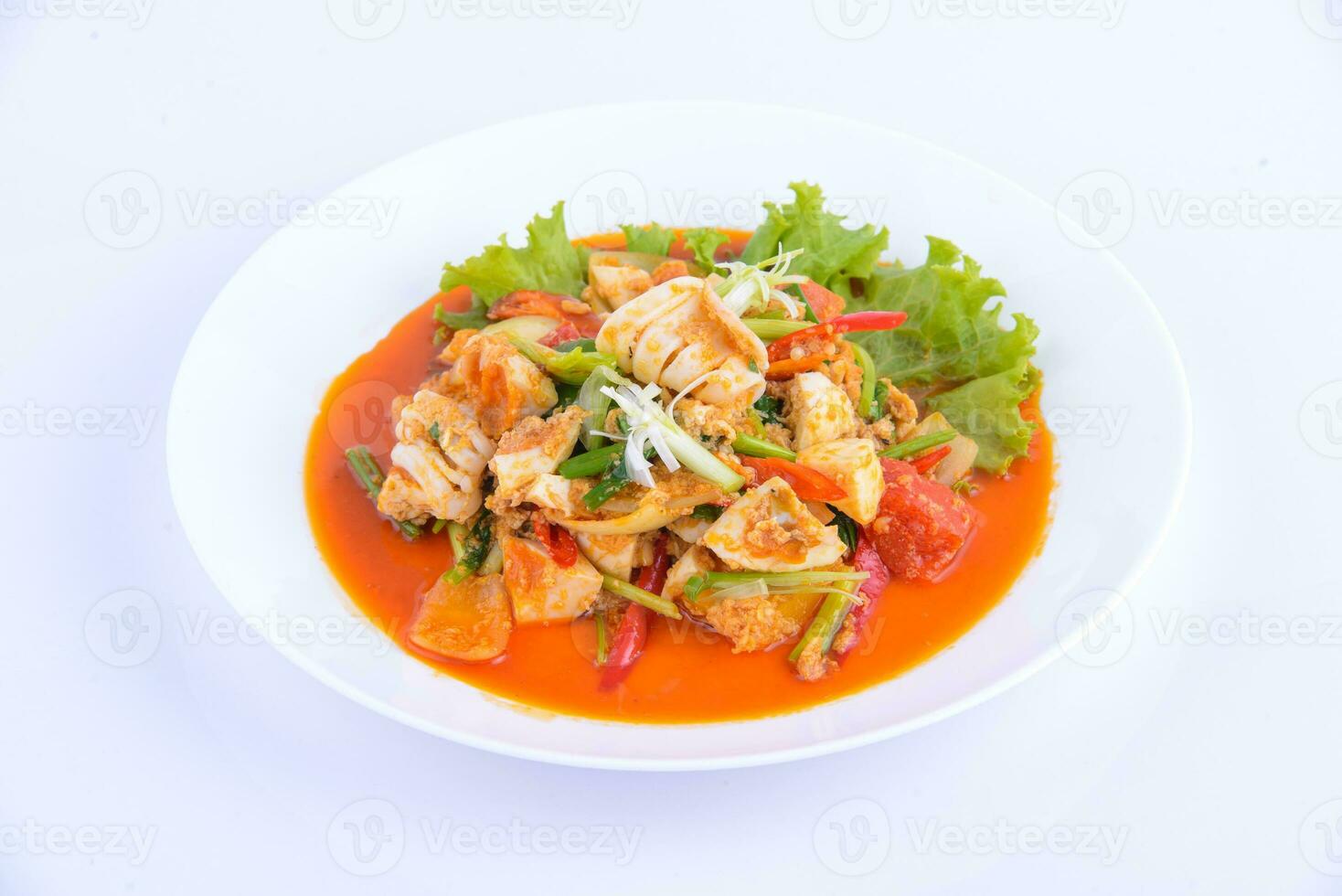 thailändisches Lieblingsessen. Gebratener Tintenfisch mit Curry auf dem weißen Teller umrühren. foto