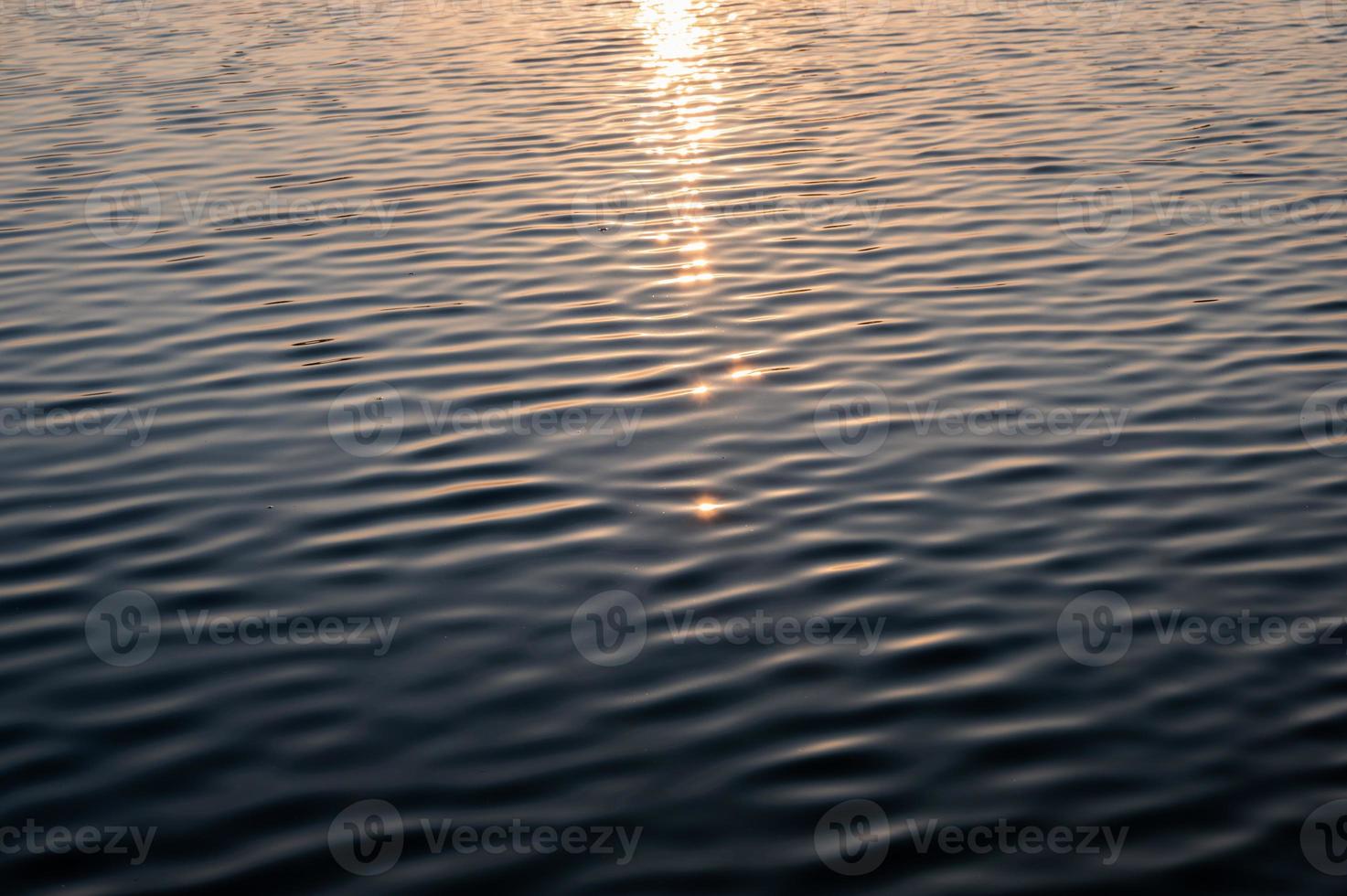 Sonnenschein auf gewelltem Wasser im See am Morgen foto