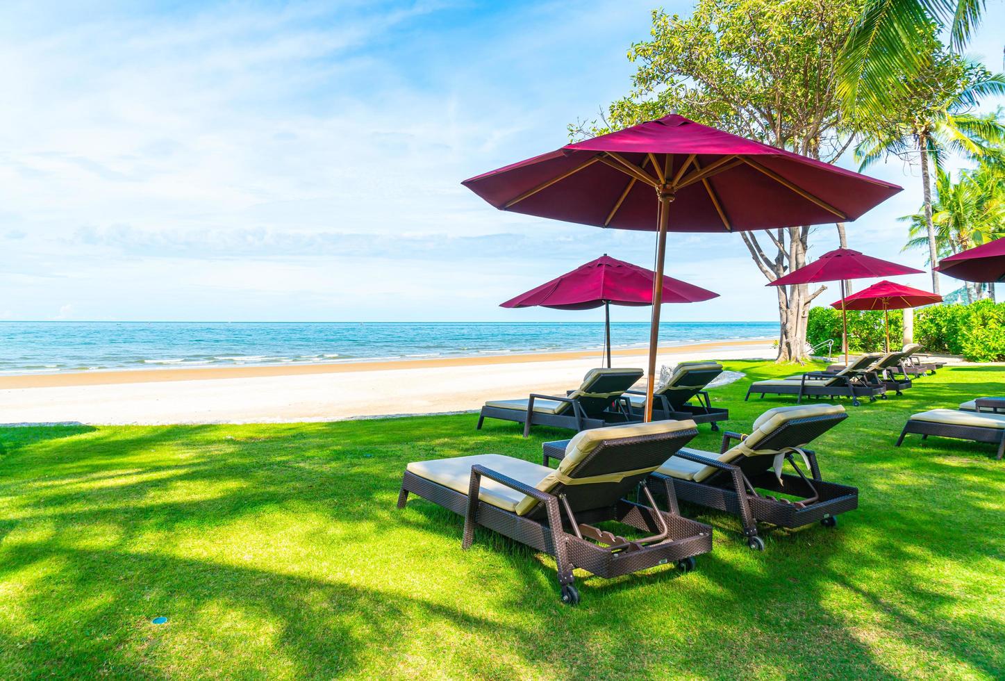 Strandkörbe und Sonnenschirme mit Ozean Meer Strand Hintergrund foto