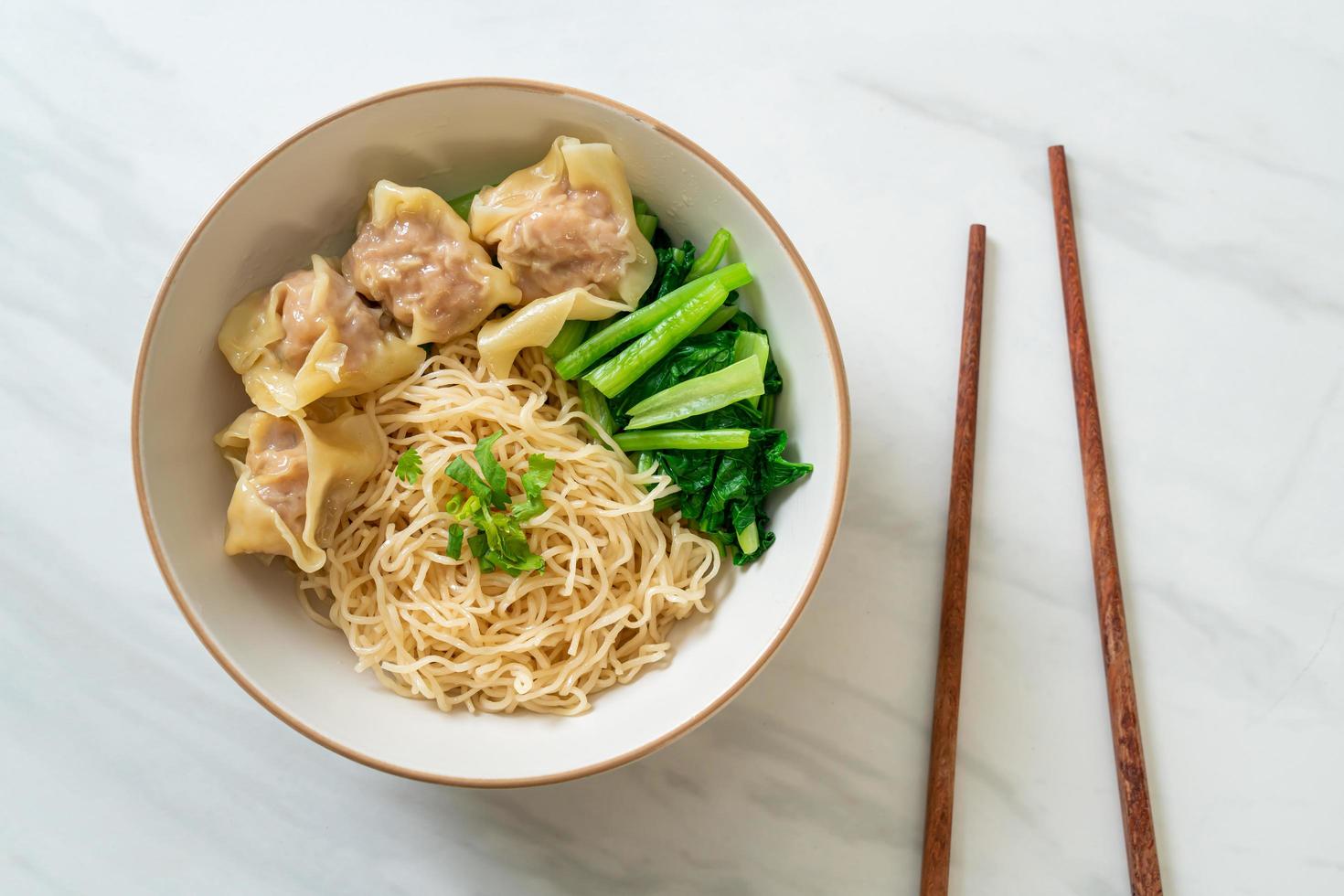 getrocknete Eiernudeln mit Schweinefleisch Wonton oder Schweineknödel ohne Suppe - asiatische Küche foto