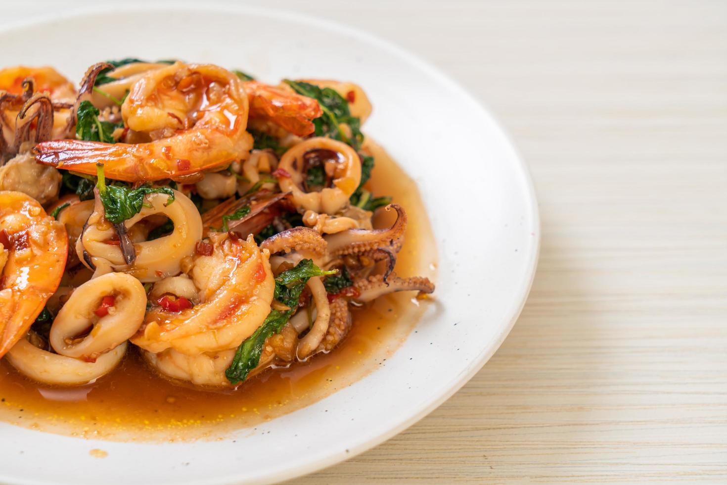 Reis und gebratene Meeresfrüchte, Garnelen und Tintenfisch, mit thailändischem Basilikum - asiatische Küche food foto