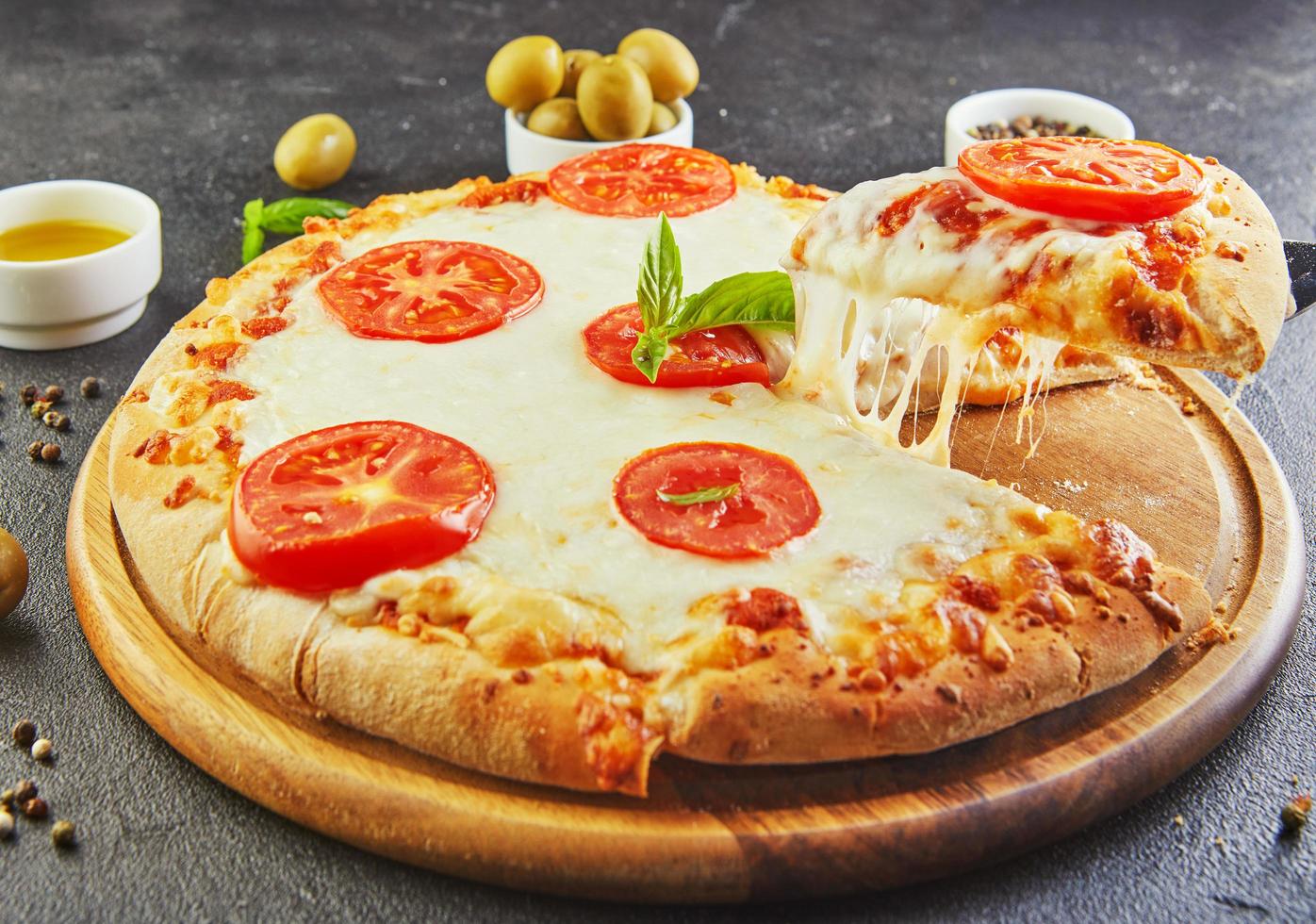 der köstliche Geschmack von Pizza und Käsescheiben mit Mozzarella und Tomaten Dreieckspizza mit Stretching-Käse und Gewürzen foto