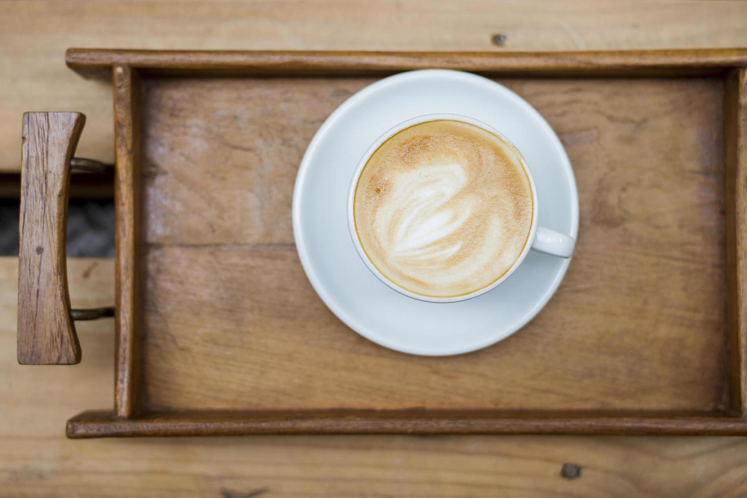 heiße Latte Art auf Holztischhintergrund foto