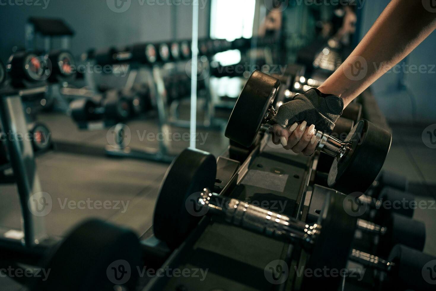 Nahansicht Frau Hände Heben Hanteln beim Fitnessstudio. foto