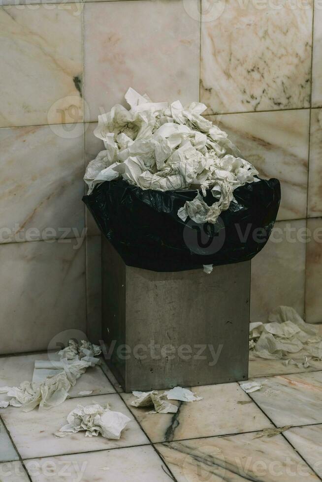 Eimer voll von Papier Handtücher im ein Toilette foto