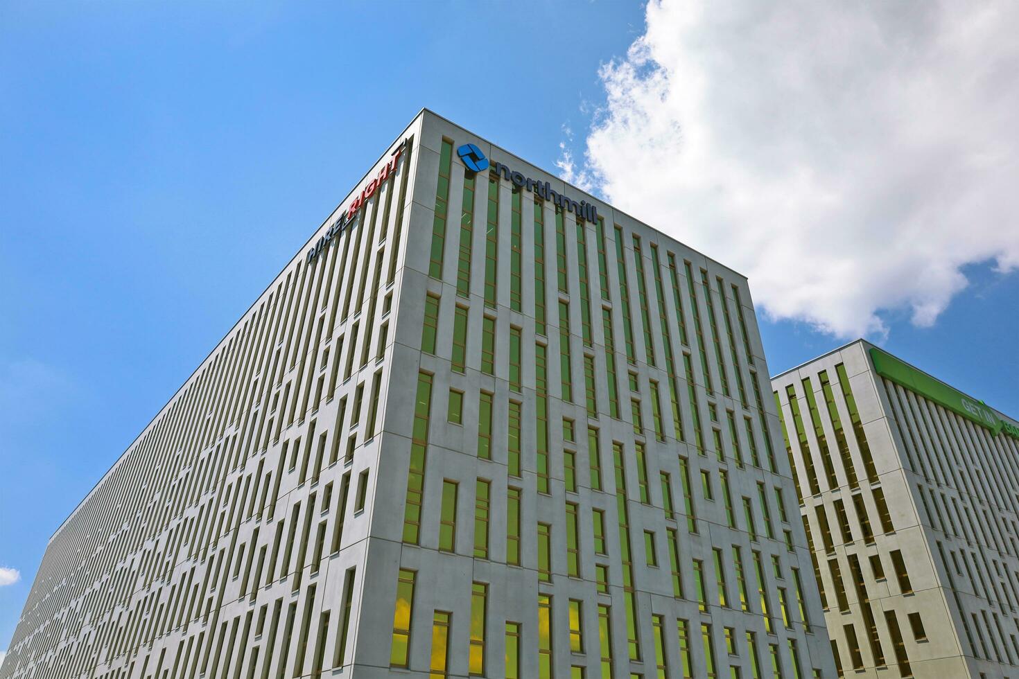 Kattowitz, Polen, 2021 - - Büro Komplex Schlesien Star gemacht von Gelb getönt Glas und Beton Konstruktionen unter Blau Himmel. Unterseite Perspektive. Logos von Leihrecht, Northmill, Treten Sie ein Bank auf oben foto