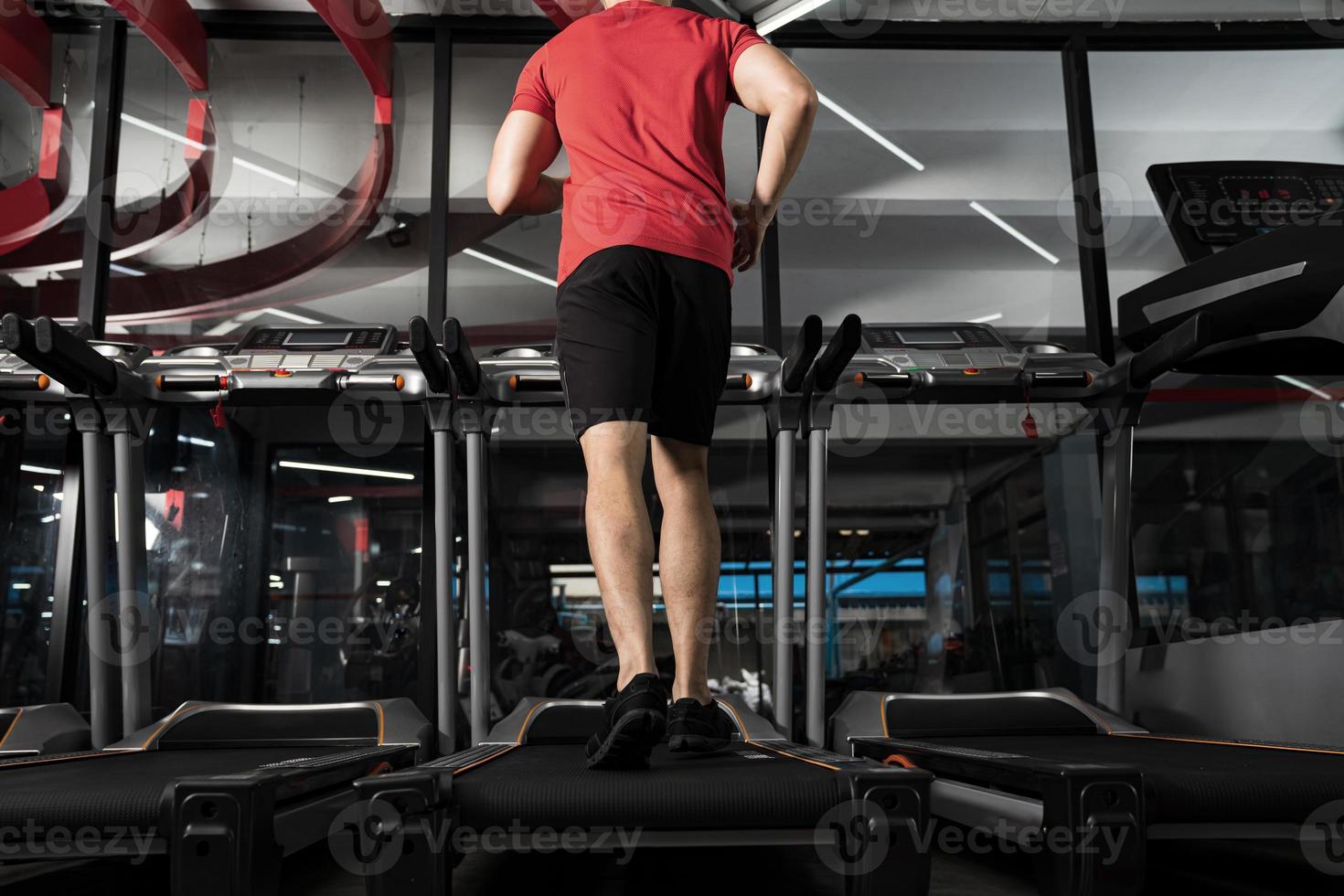 athletischer junger Mann, der im Fitnessstudio Sport Fitnesstraining läuft foto