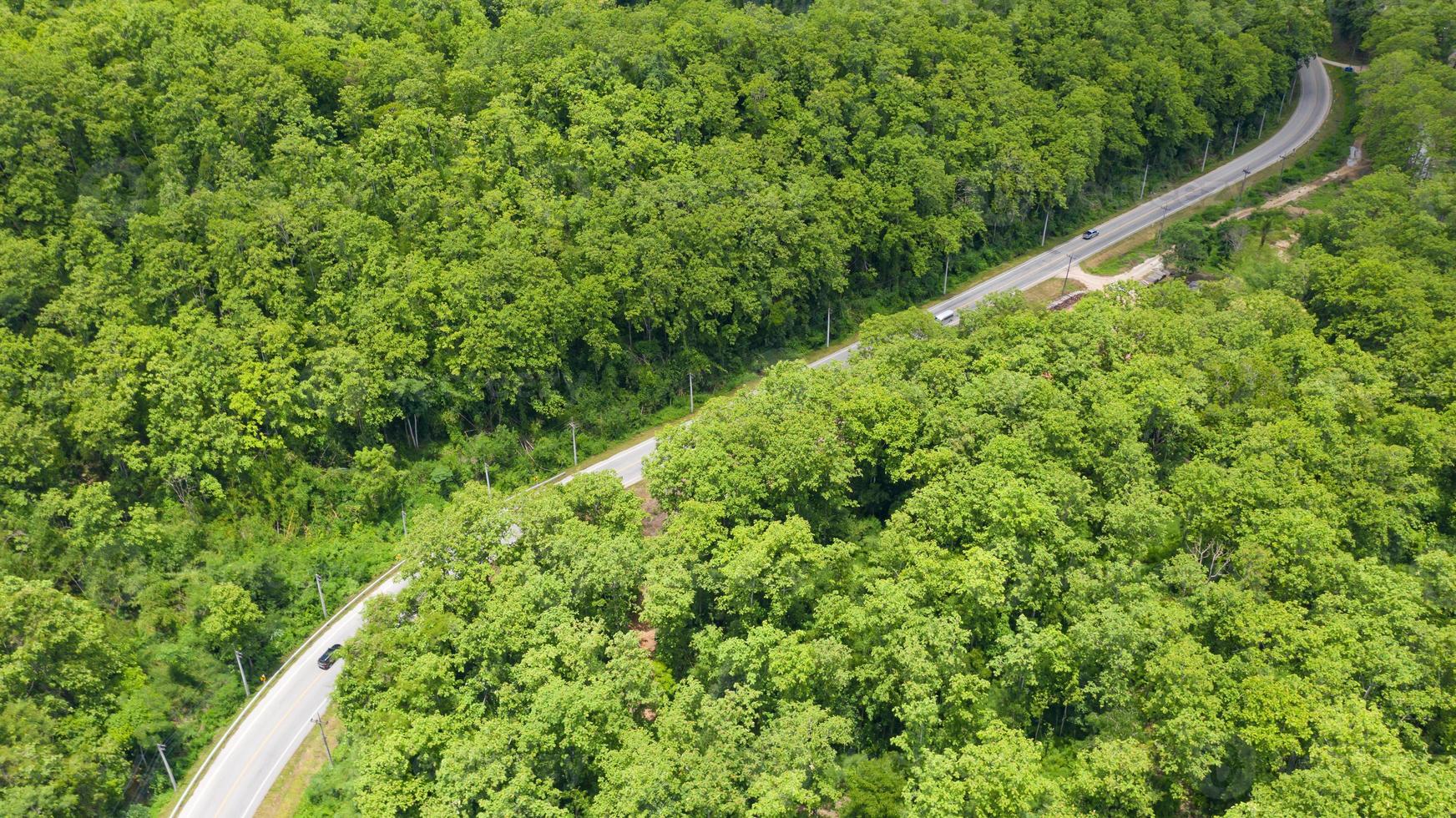 Luft Draufsicht einer Provinzstraße, die durch einen Waldhintergrund geht foto