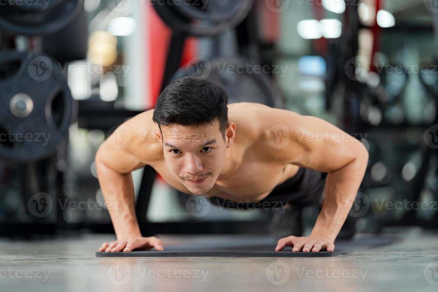sportlicher Mann trainiert Liegestütze im Fitnessstudio foto