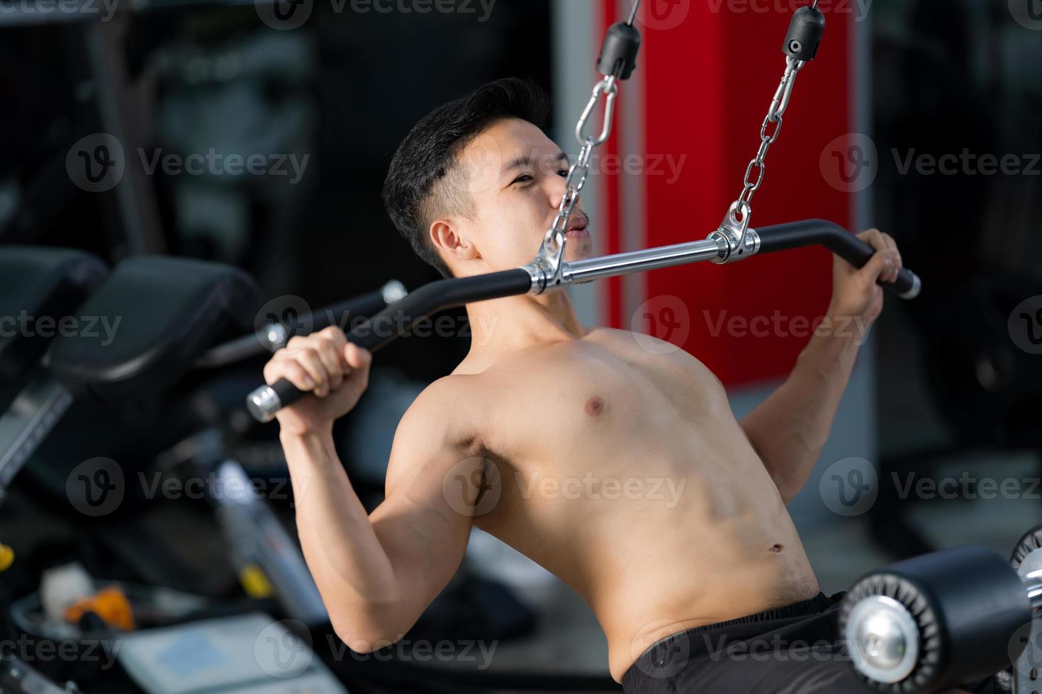 Sportlicher Mann, der Übung im Fitnessstudio trainiert foto