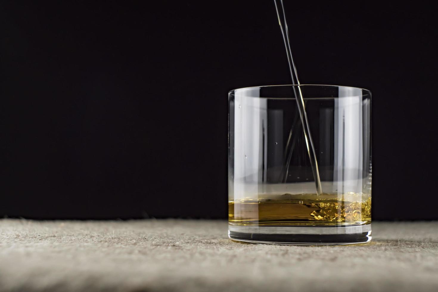 Whisky wird in ein Glas gegossen foto