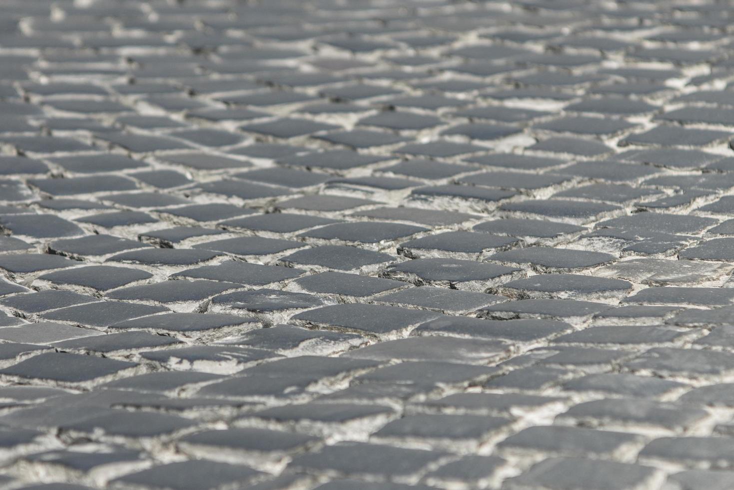 Bürgersteig in der Altstadt von schwarzem Kopfsteinpflaster Hintergrundtextur foto