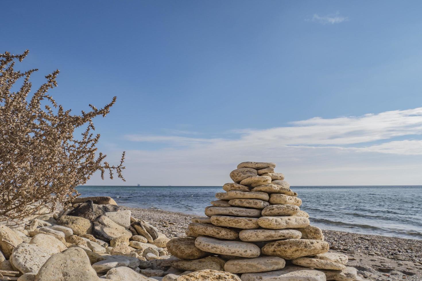 balancierende Steinhaufenpyramide auf der Ufertapete foto