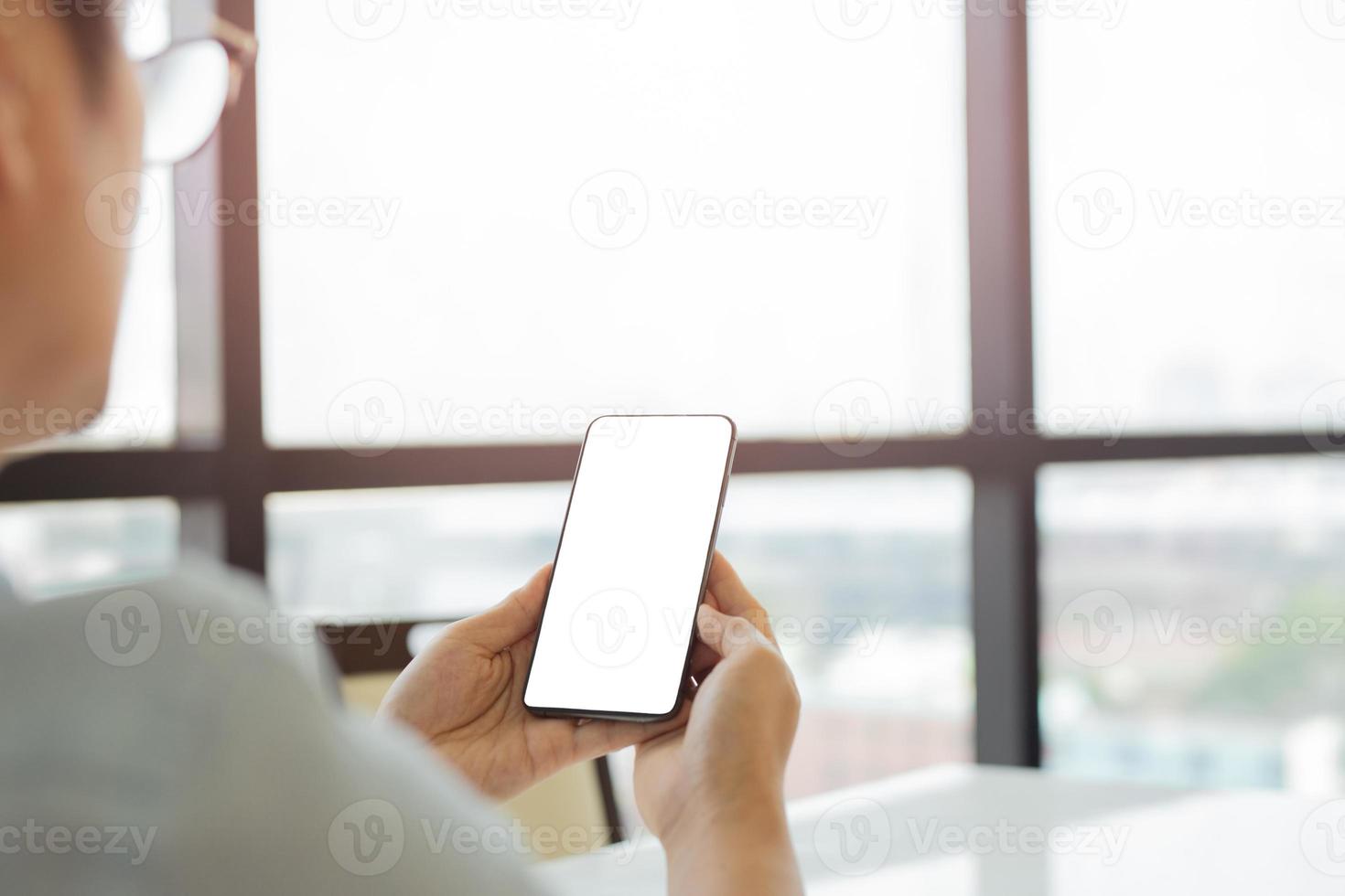 Mannhände mit Smartphone mit leerem weißen Bildschirm foto