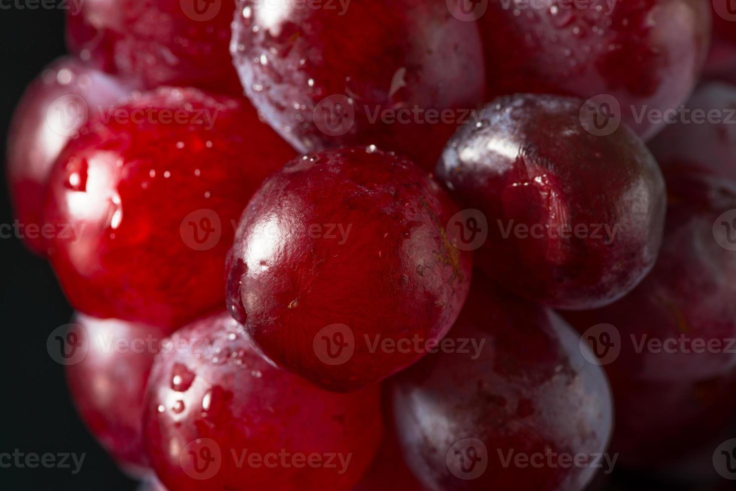 rote Trauben auf schwarzem Acryl foto