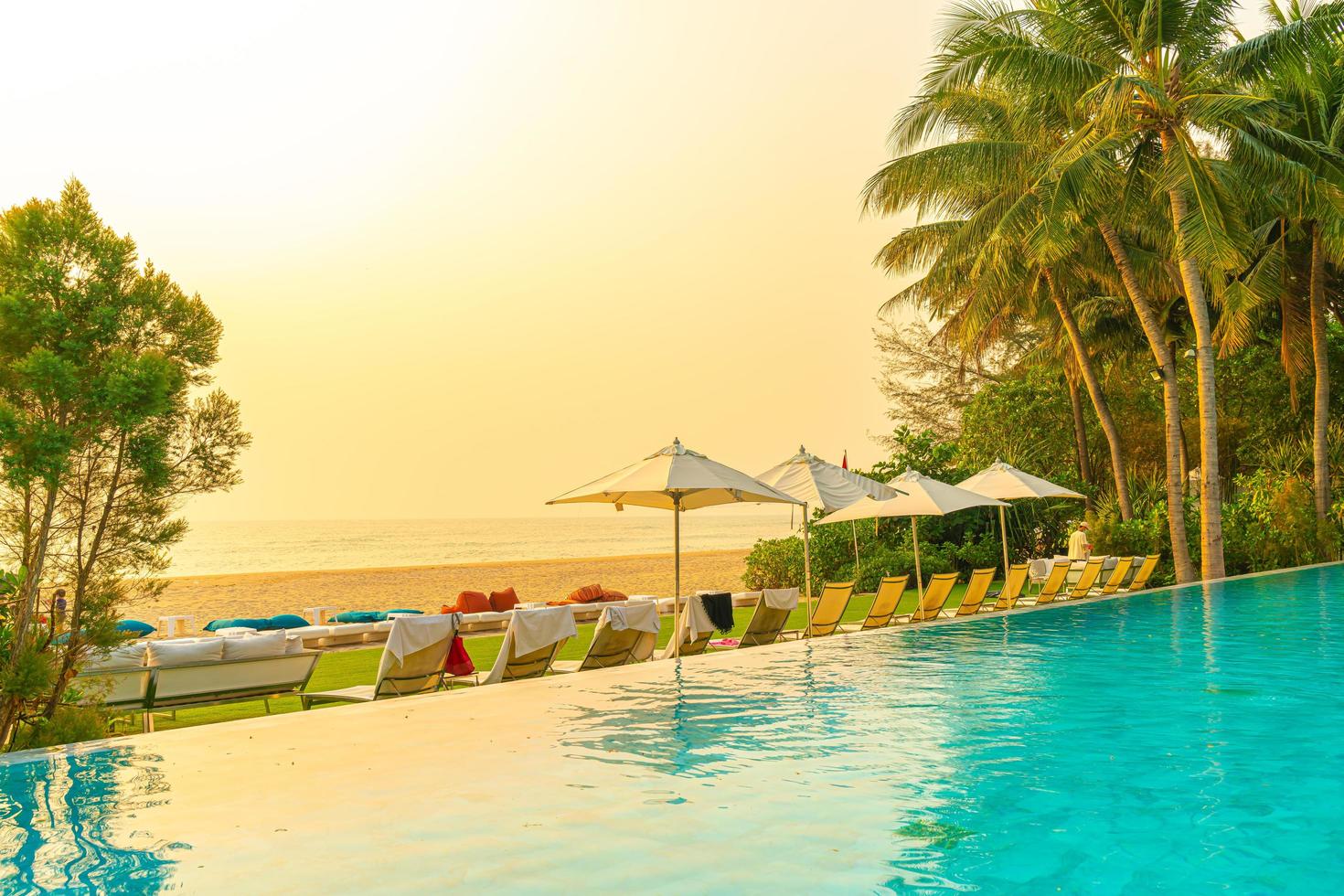 Sonnenschirm und Stuhl rund um den Pool mit Meerblick foto