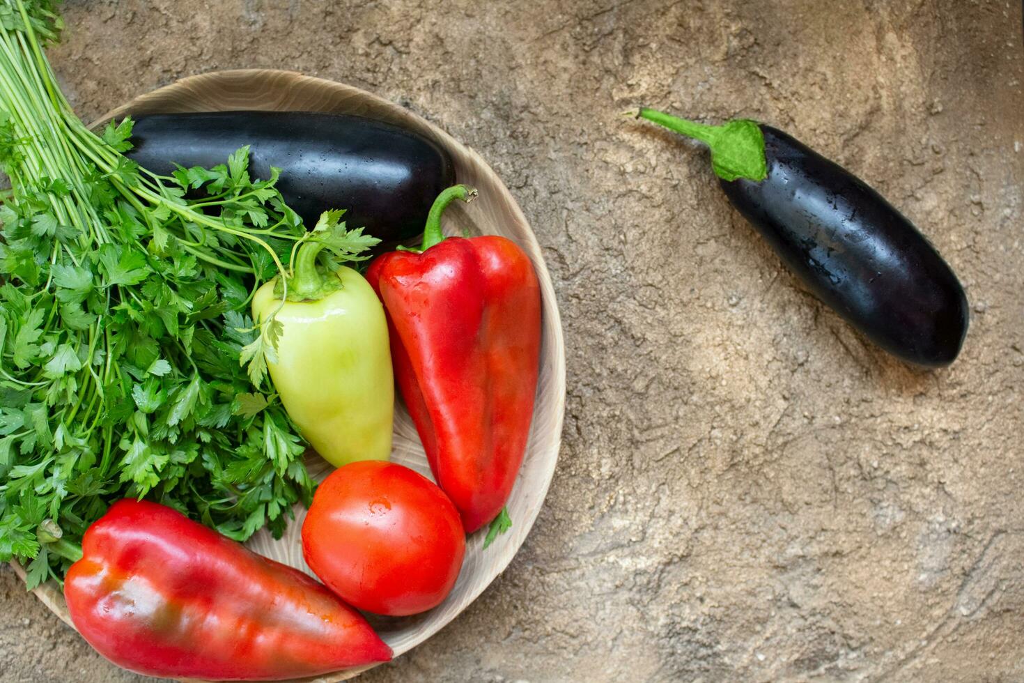 rot Tomate, Pfeffer, Petersilie, Aubergine Lüge auf ein hölzern Teller auf ein braun Hintergrund. Zutat zum Kochen. oben Sicht. Kopieren Raum foto