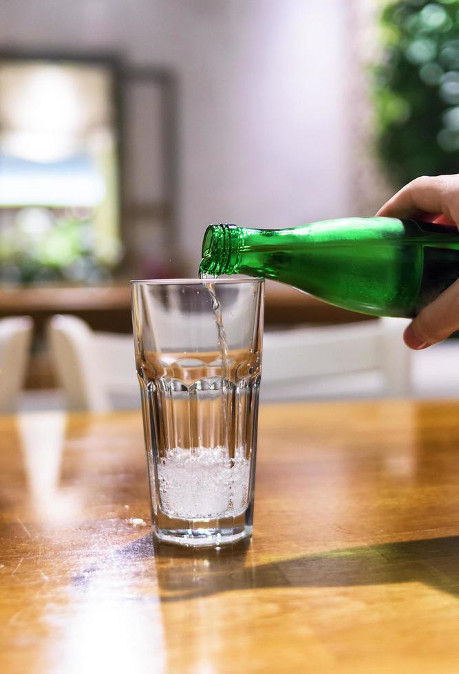 Mineralwasser ins Glas gießen foto