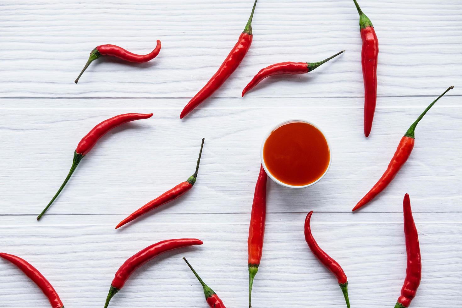 frische Chilis mit scharfer Chilisauce auf dem Tisch foto