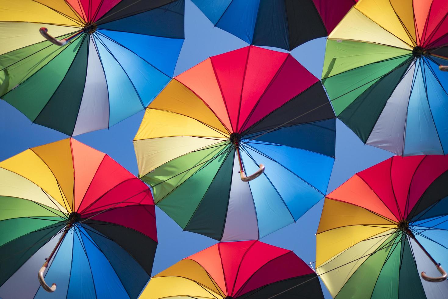 bunter Hintergrund von schönen Regenschirmen gegen den blauen Himmel foto