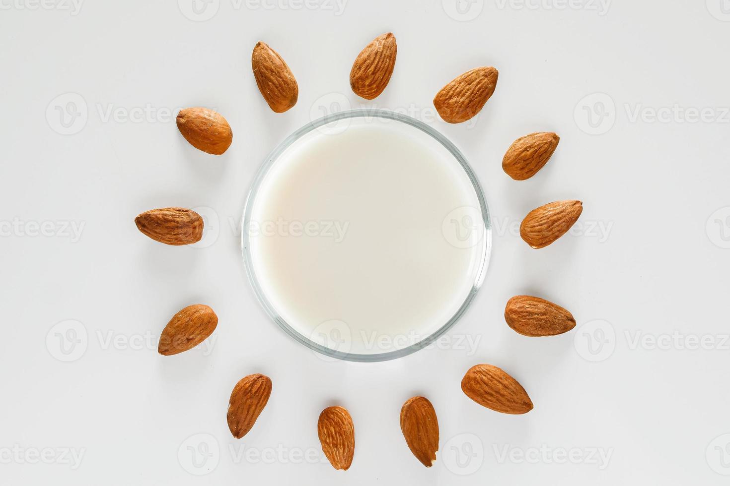 ein Glas Mandelmilch auf einem weißen Hintergrund foto