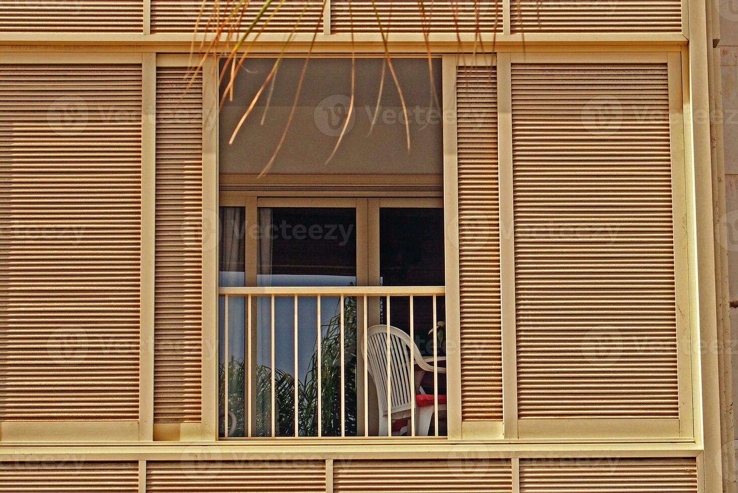 Hintergrund mit ein Fenster und Balkon umgeben durch ein hölzern blind auf ein warm Sommer- Tag foto