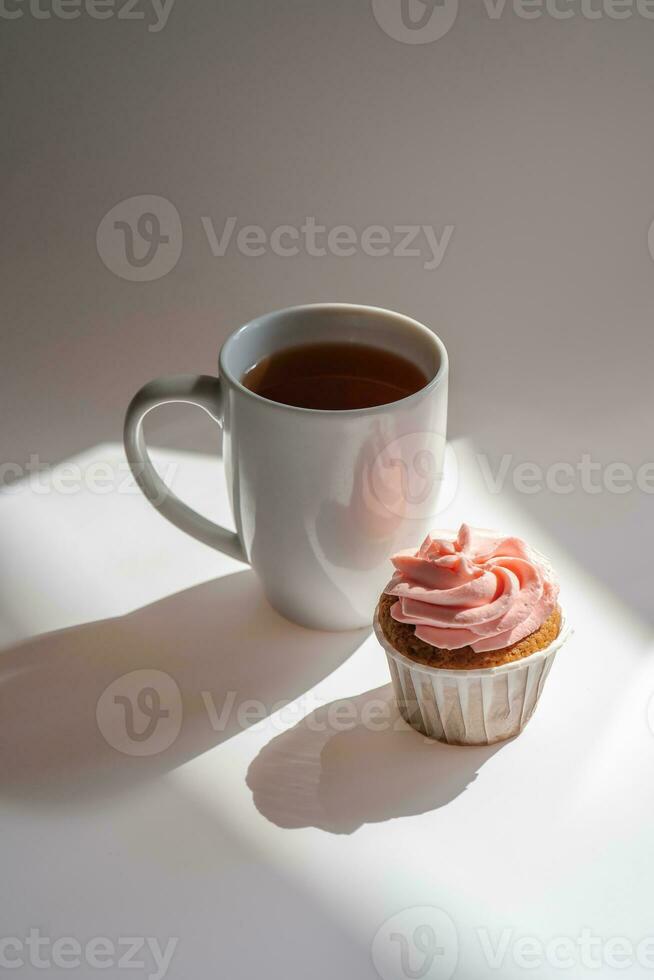 ein Cupcake oder Muffin steht Nächster zu ein Tasse von Kaffee. foto