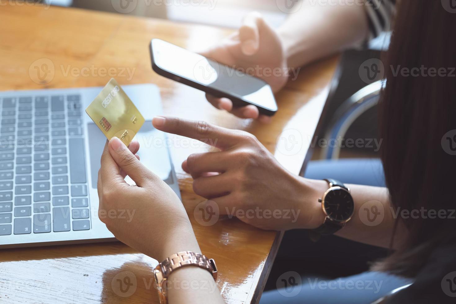 zwei Personen mit Smartphone und Computer für Online-Shopping foto