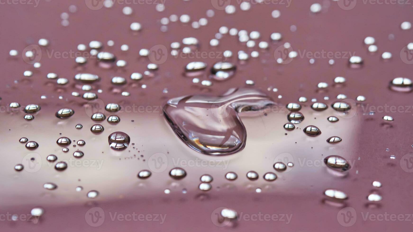 ein groß fallen und spritzt von mizellar Wasser auf ein Rosa Hintergrund. foto