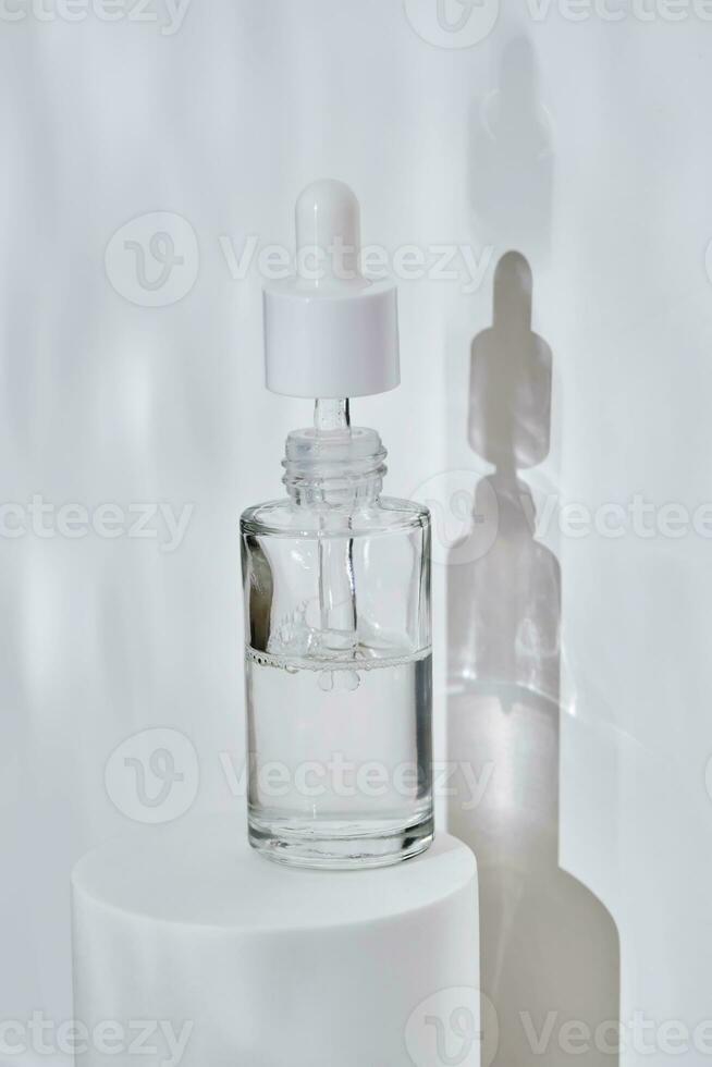 ein Flasche von Serum im Wasser auf ein Weiß Hintergrund. foto