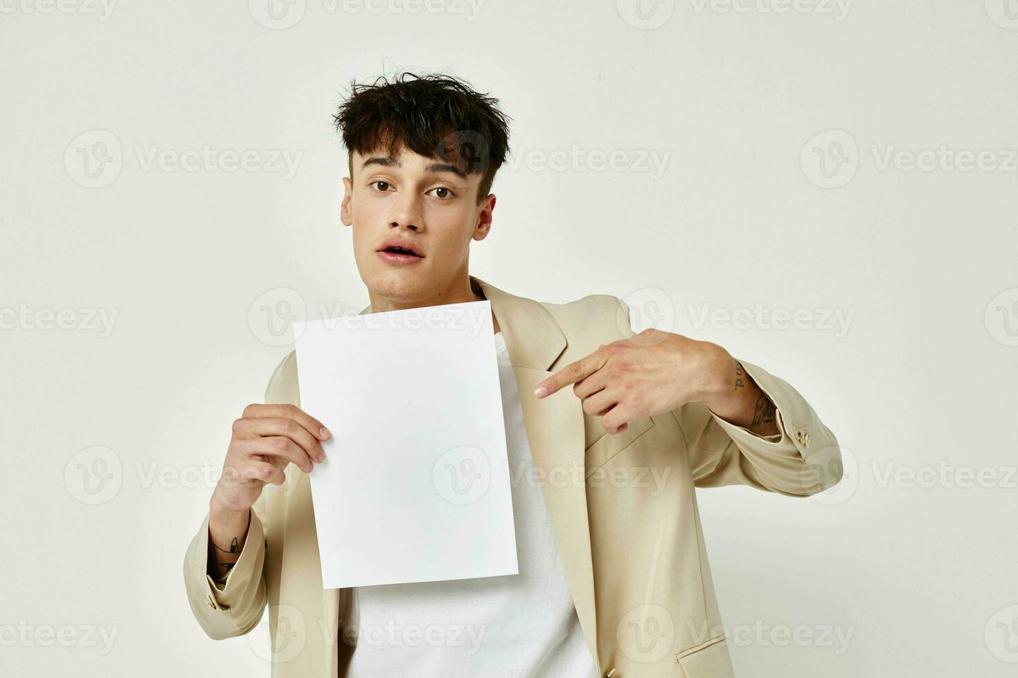 Mann posieren mit ein Weiß Blatt von Papier Licht Hintergrund unverändert foto