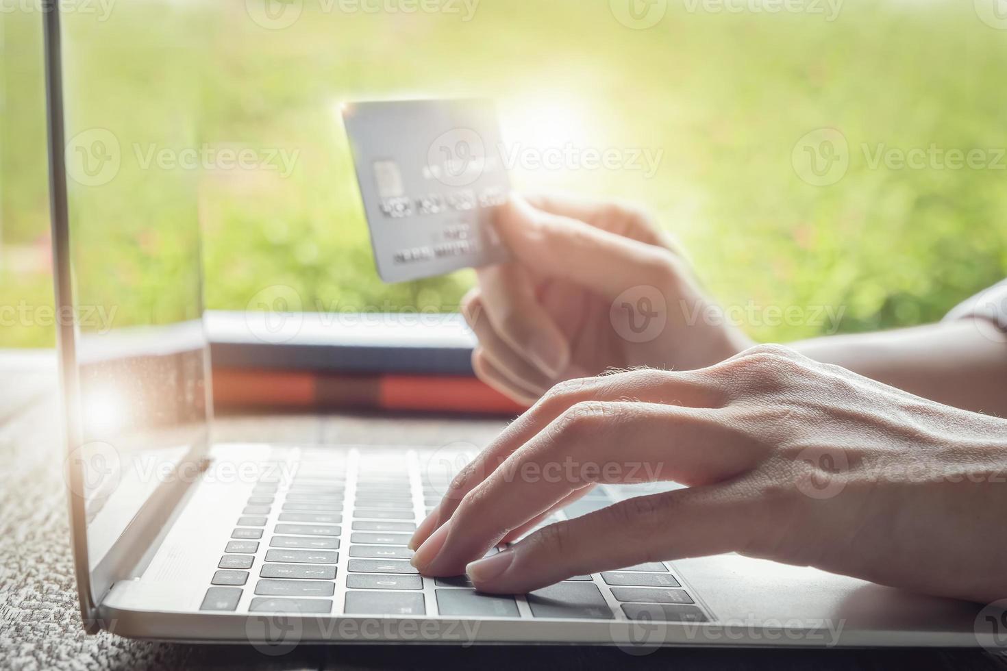 Online-Zahlungskonzept mit Frau, die Computer verwendet und Kreditkarte hält foto