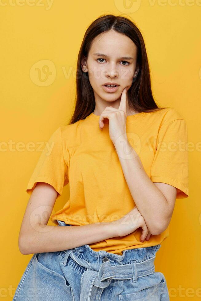 optimistisch jung Frau im ein Gelb T-Shirt Emotionen Sommer- Stil Gelb Hintergrund foto