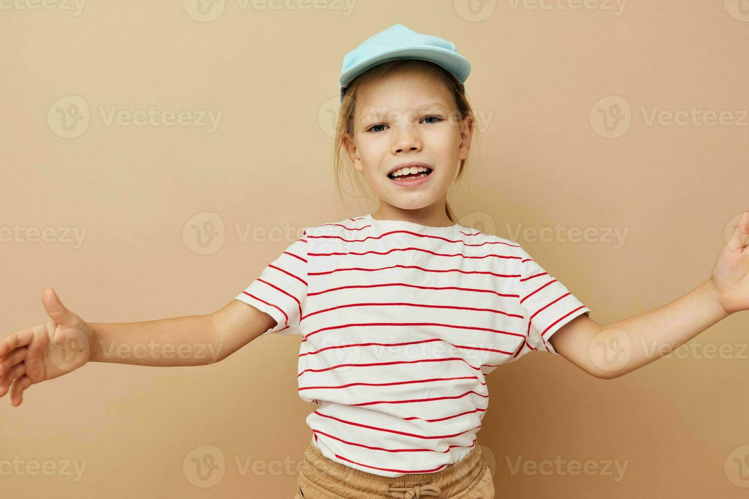 wenig Mädchen im Blau Kappen gestreift T-Shirt Emotionen Lebensstil unverändert foto