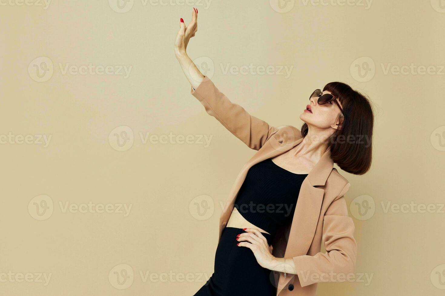 Foto ziemlich Frau im ein Beige Jacke elegant Stil Sonnenbrille isoliert Hintergrund