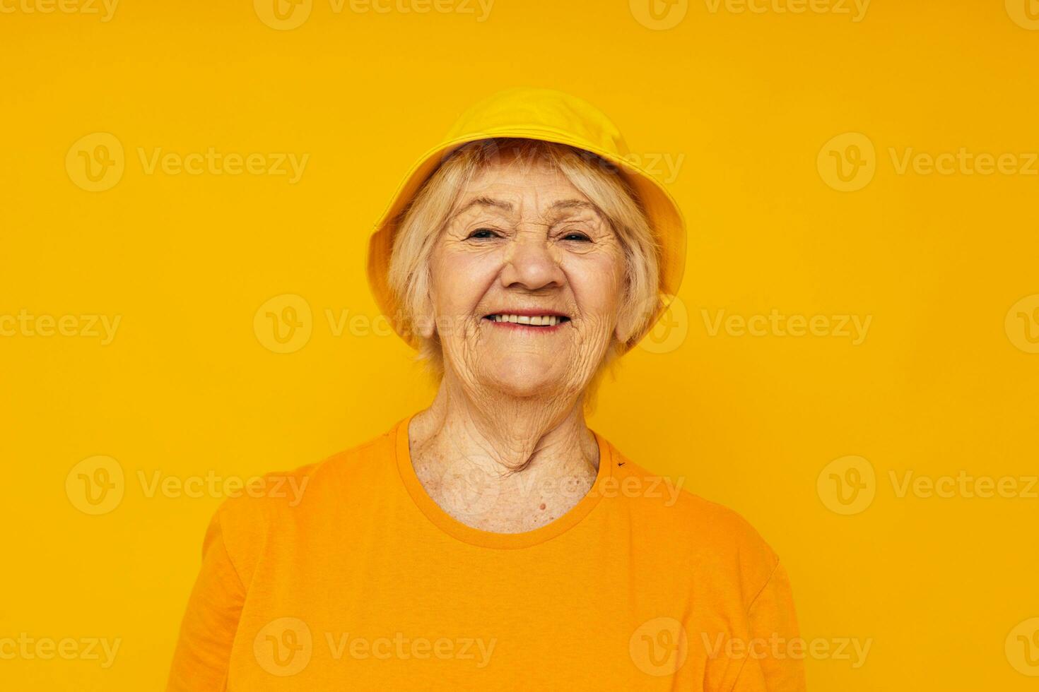 Foto von im Ruhestand alt Dame glücklich Lebensstil im ein Gelb Kopfschmuck Gelb Hintergrund