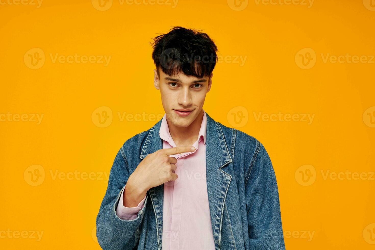 gut aussehend Mann im Denim Jacke Jugend Stil posieren Gelb Hintergrund foto