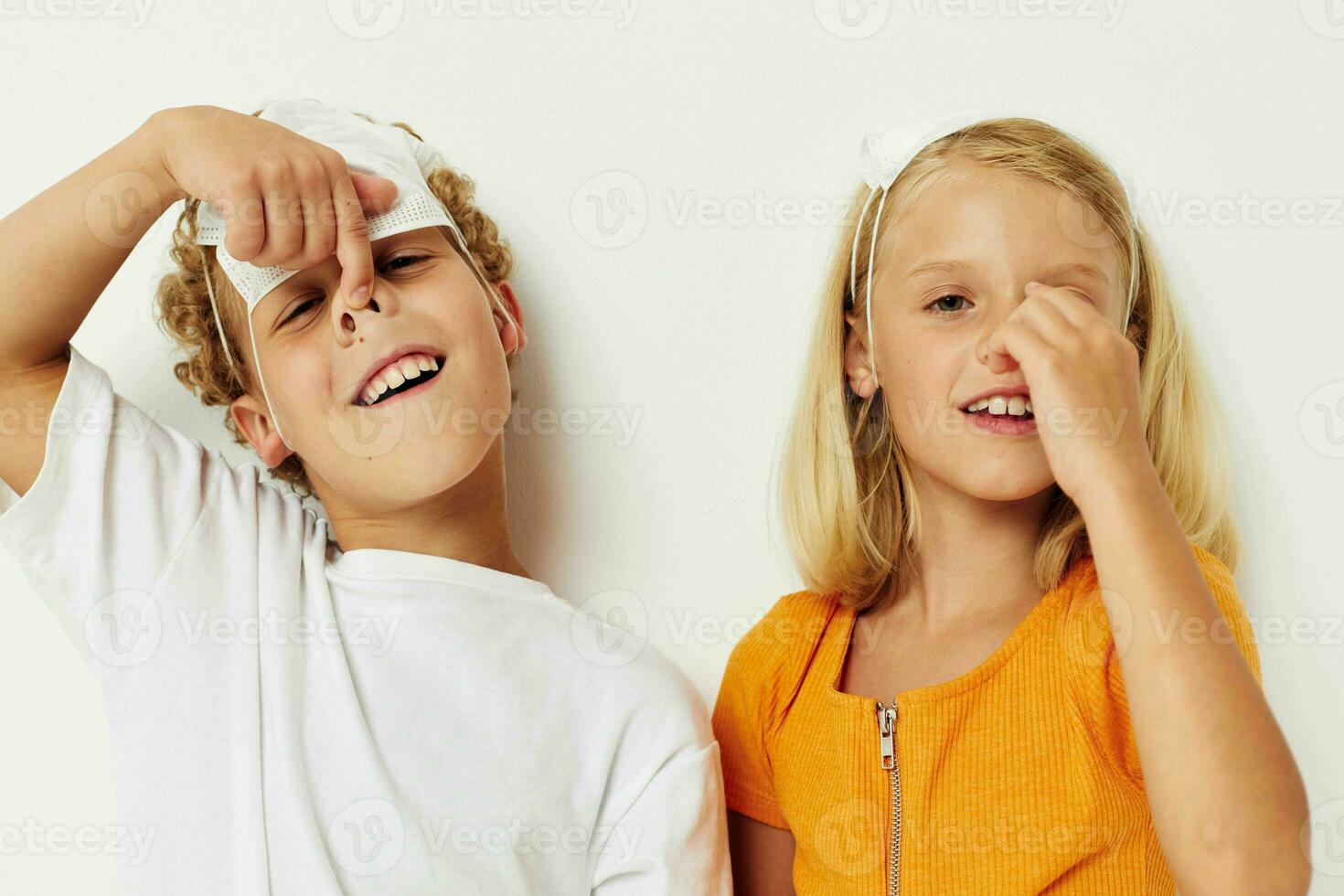 Bild von positiv Junge und Mädchen im ein medizinisch Maske Spaß isoliert Hintergrund unverändert foto