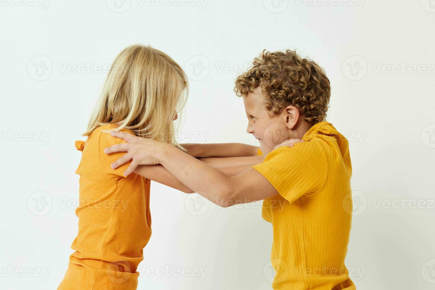 Porträt von süß Kinder im Gelb T-Shirts Stehen Seite durch Seite Kindheit Emotionen unverändert foto