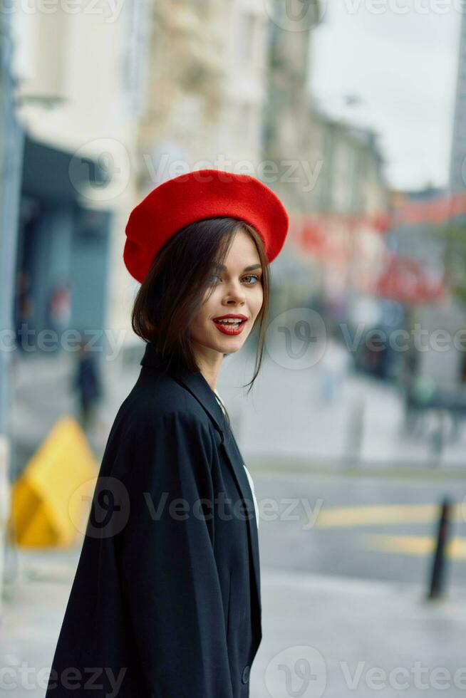 Mode Frau Lächeln Frühling Gehen im das Stadt im stilvoll Kleider mit rot Lippen und rot Baskenmütze, reisen, filmisch Farbe, retro Jahrgang Stil, städtisch Mode Lebensstil. foto