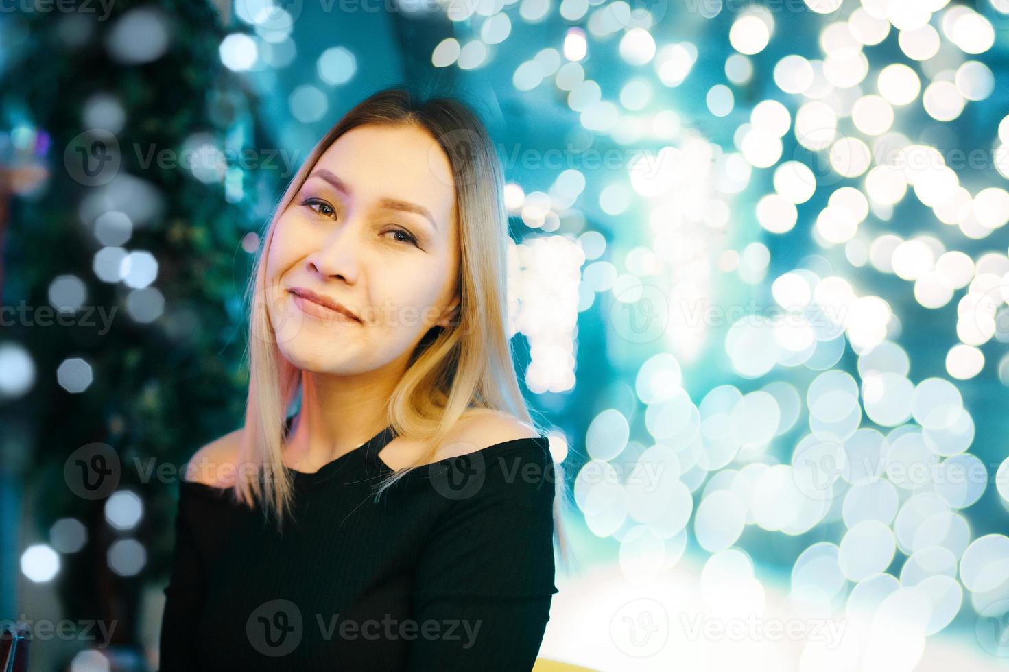 Porträt des schönen blonden Mädchens im schwarzen Kleid foto