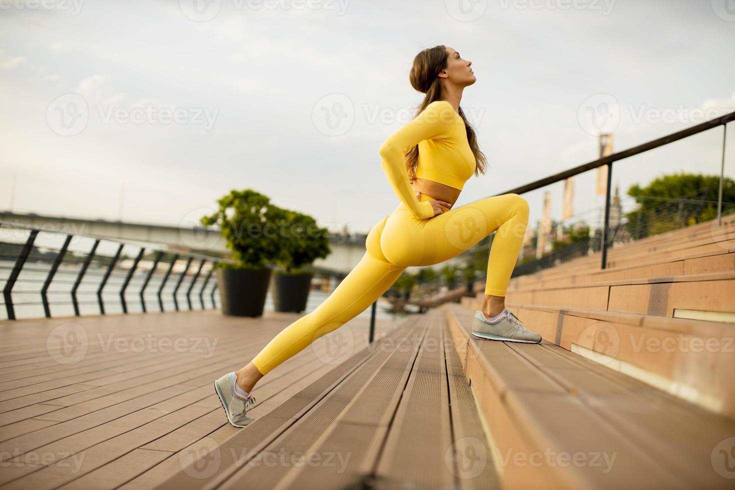 junge Frau streckt sich am Flussufer foto