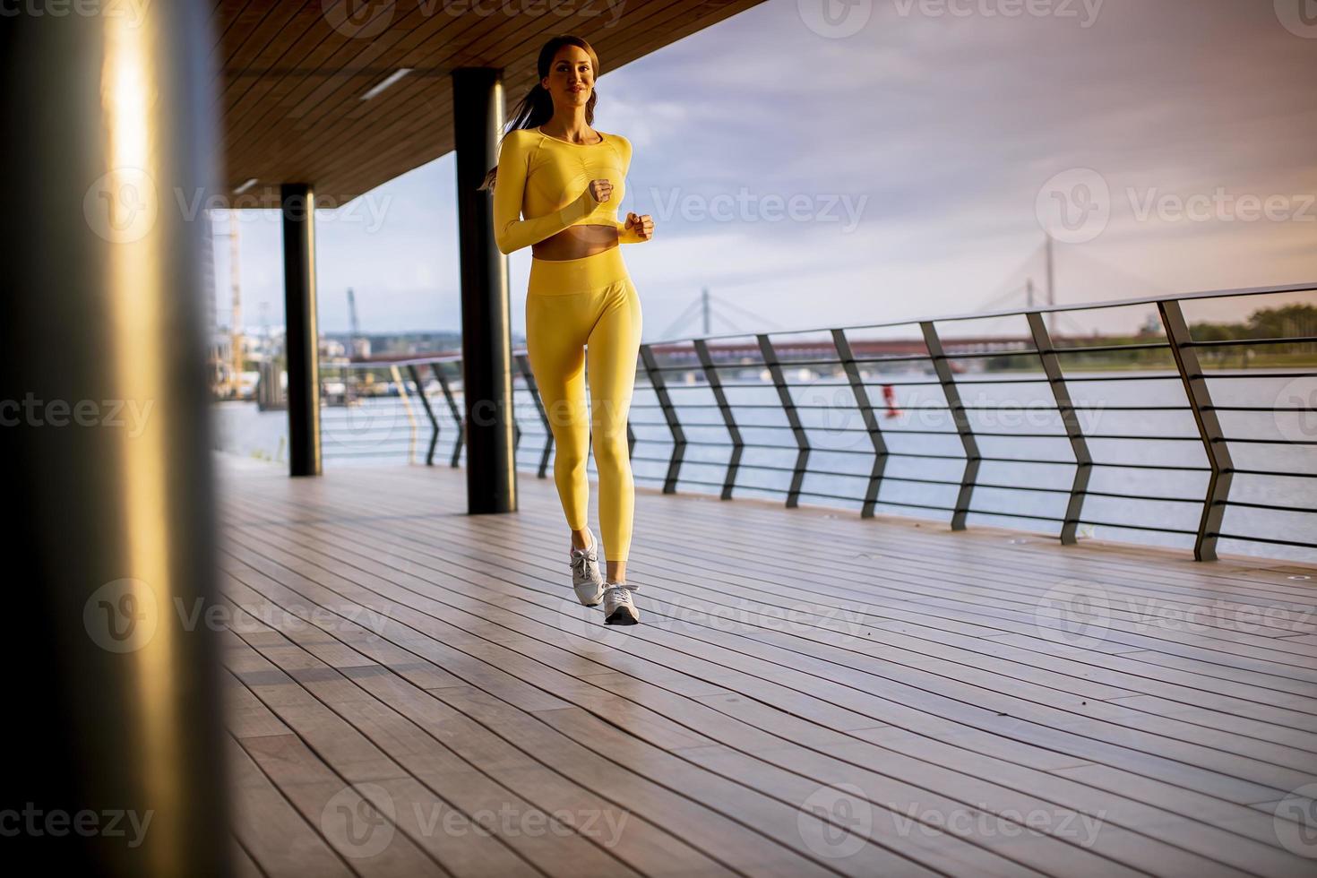 junge Frau beim Lauftraining an der Flusspromenade foto