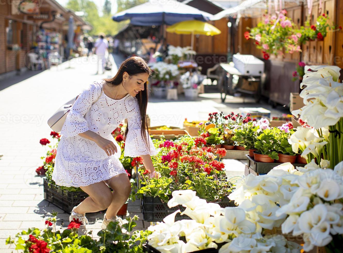 junge Frau kauft Blumen auf dem Blumenmarkt foto