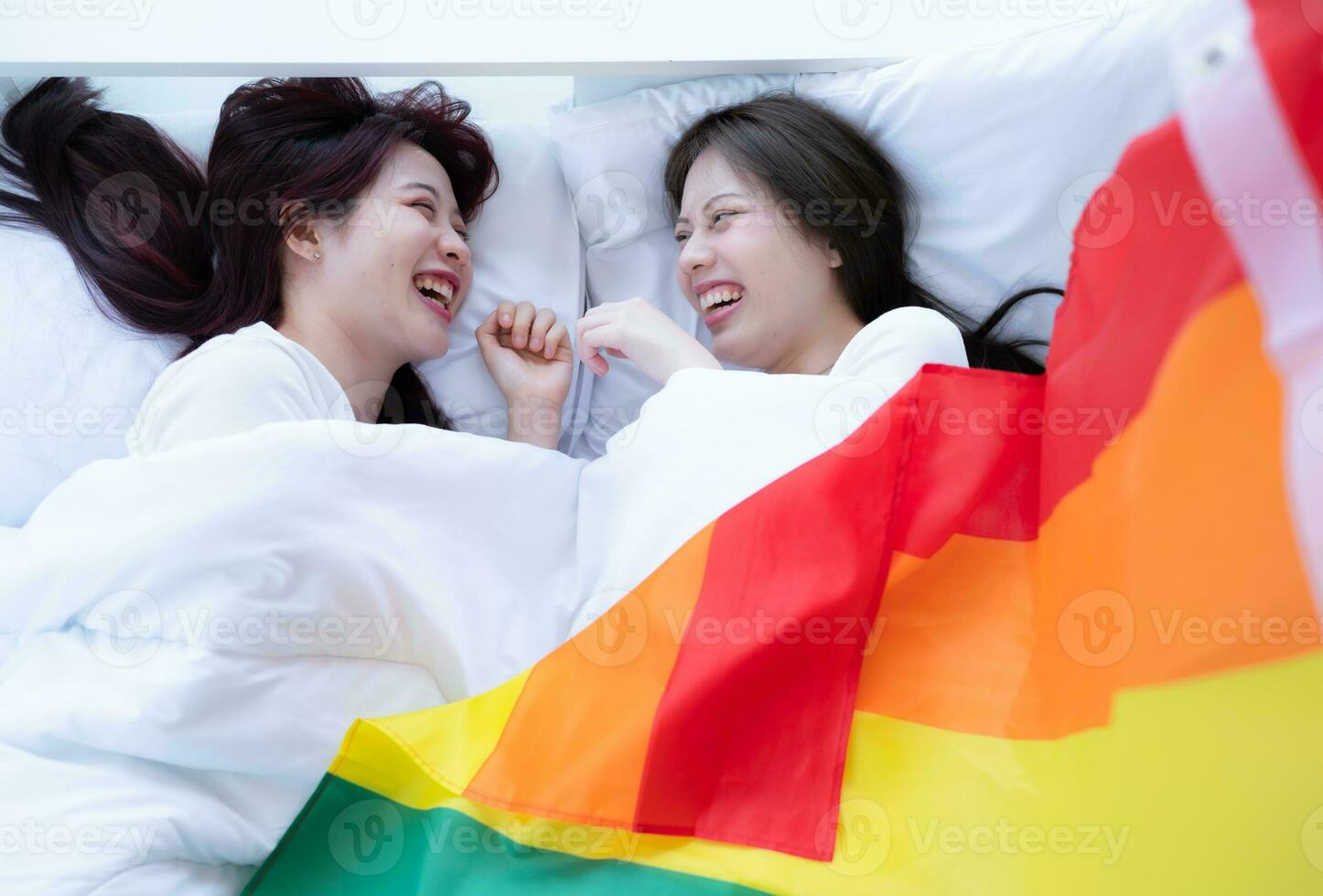 im ein Hotel Schlafzimmer, ein lgbt Paar kuschelte zusammen auf das Bett glücklich. foto