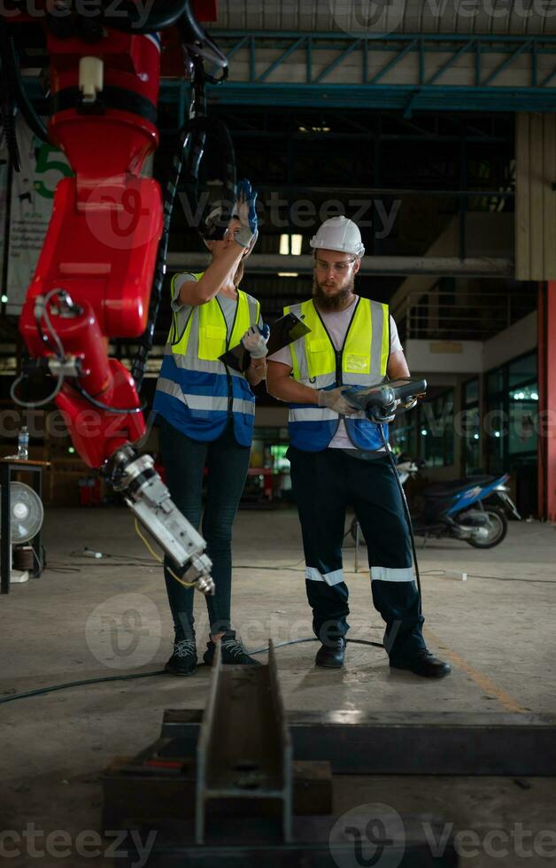 beide von Ingenieure Installation und testen ein groß Roboter Arm. Vor Senden es zu Kunden zum verwenden im das Industrie foto