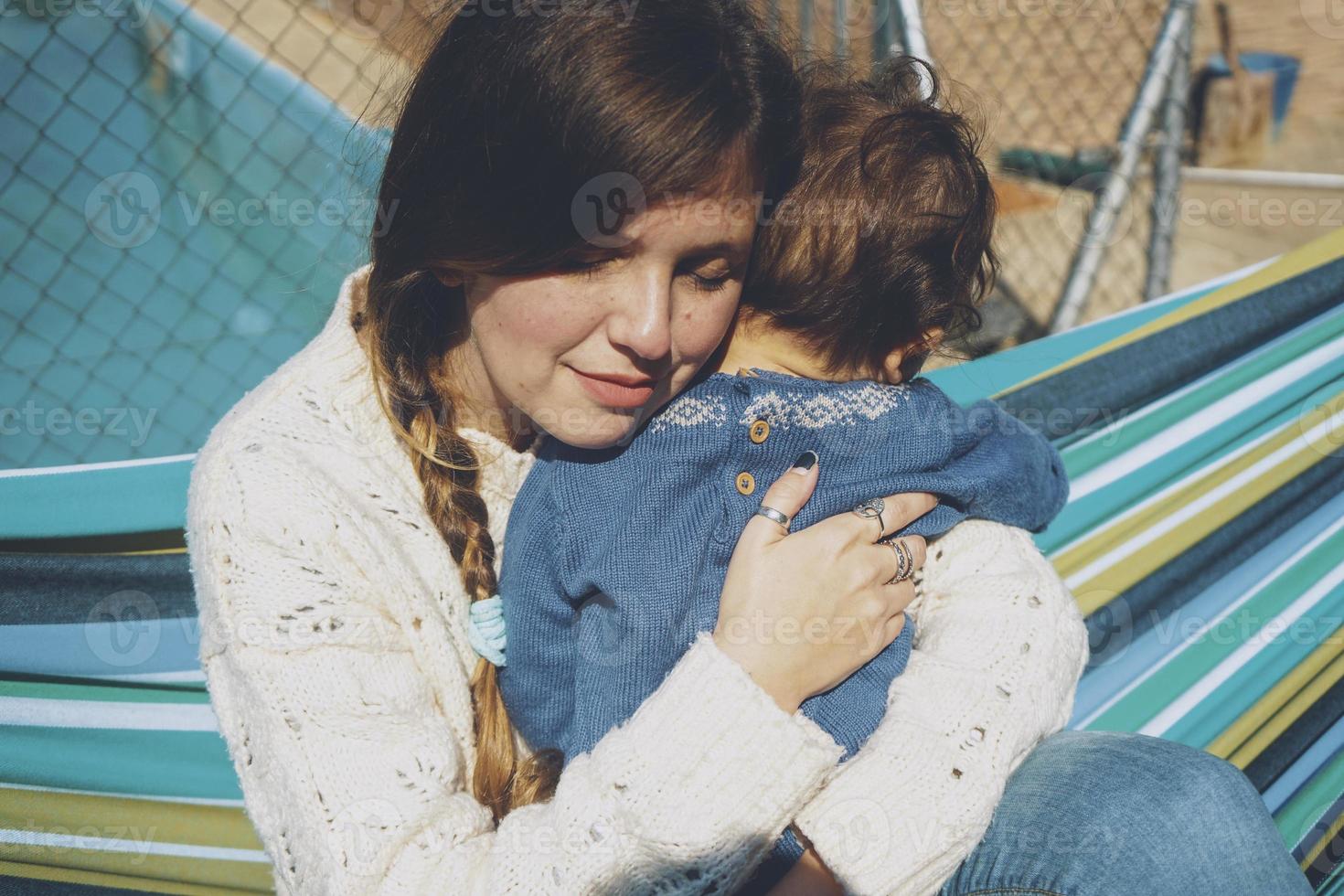 Bild über echte Mutterschaft einer jungen Mutter, die ihr Baby umarmt foto