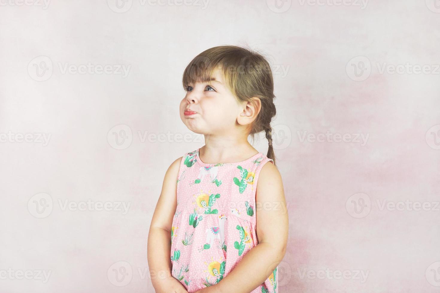 junges kleines und lustiges Mädchen in einer Studioaufnahme foto