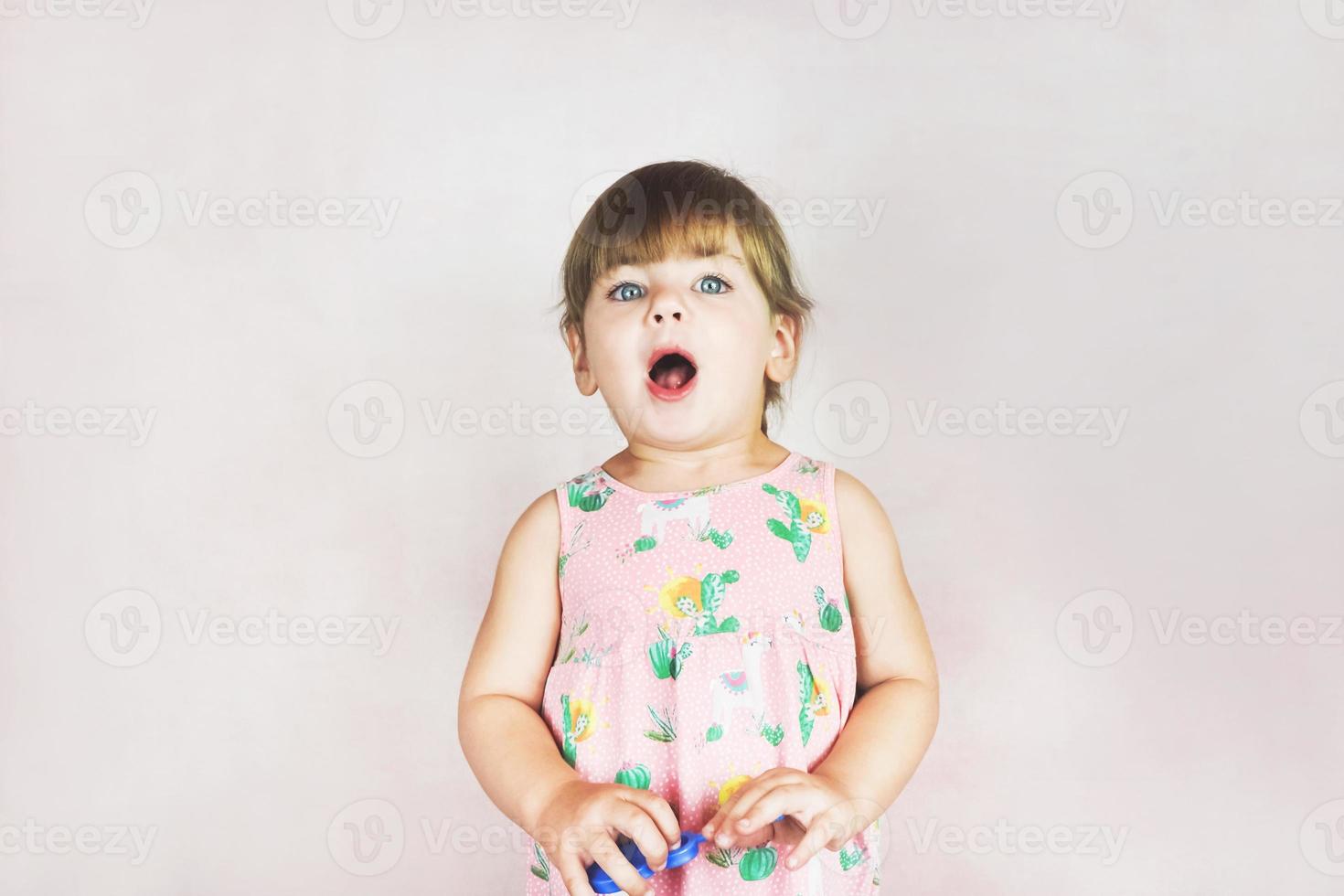 junges kleines und lustiges Mädchen in einer Studioaufnahme foto